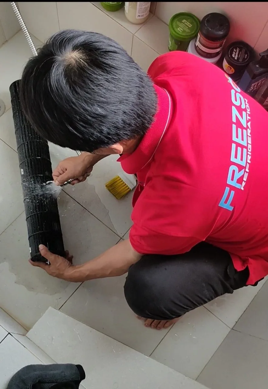 Freezso technician pressure cleaning an aircon blower