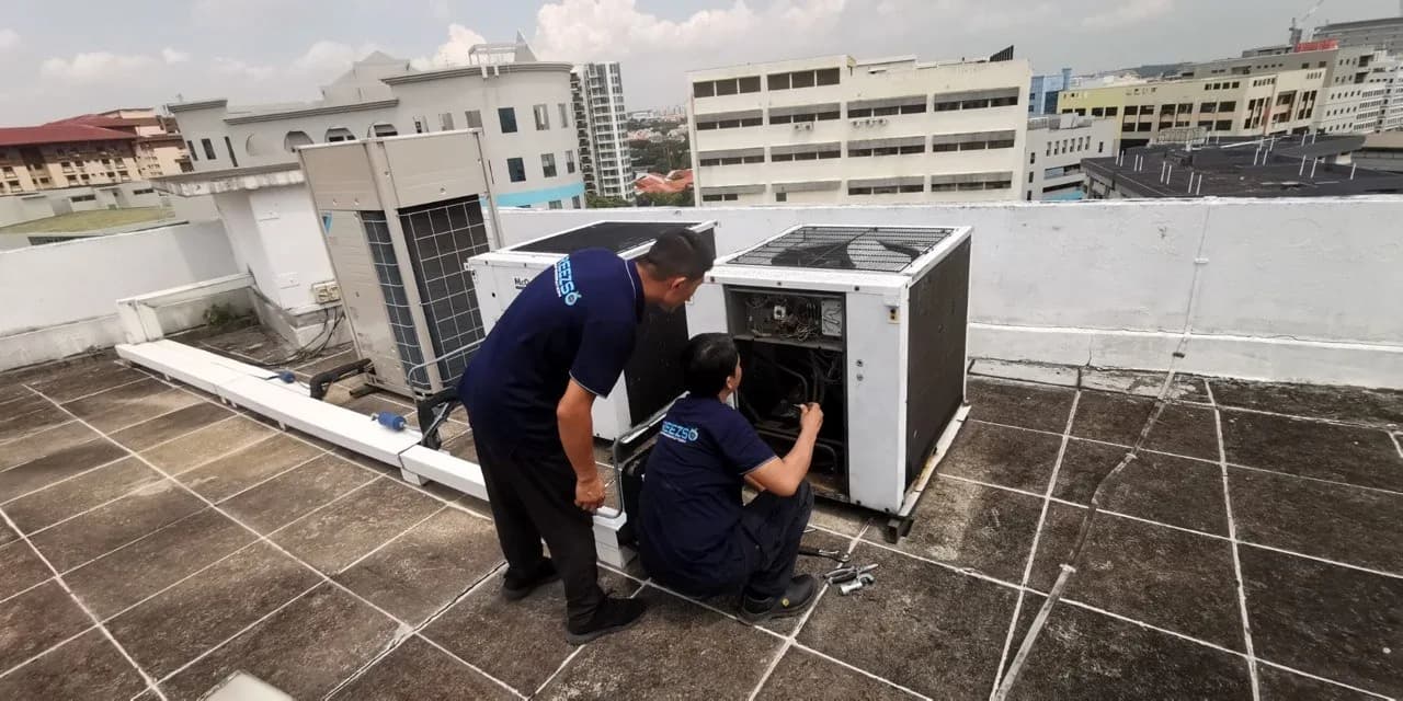 Freezso technicians repairing a commercial rooftop air-conditioning system in Singapore